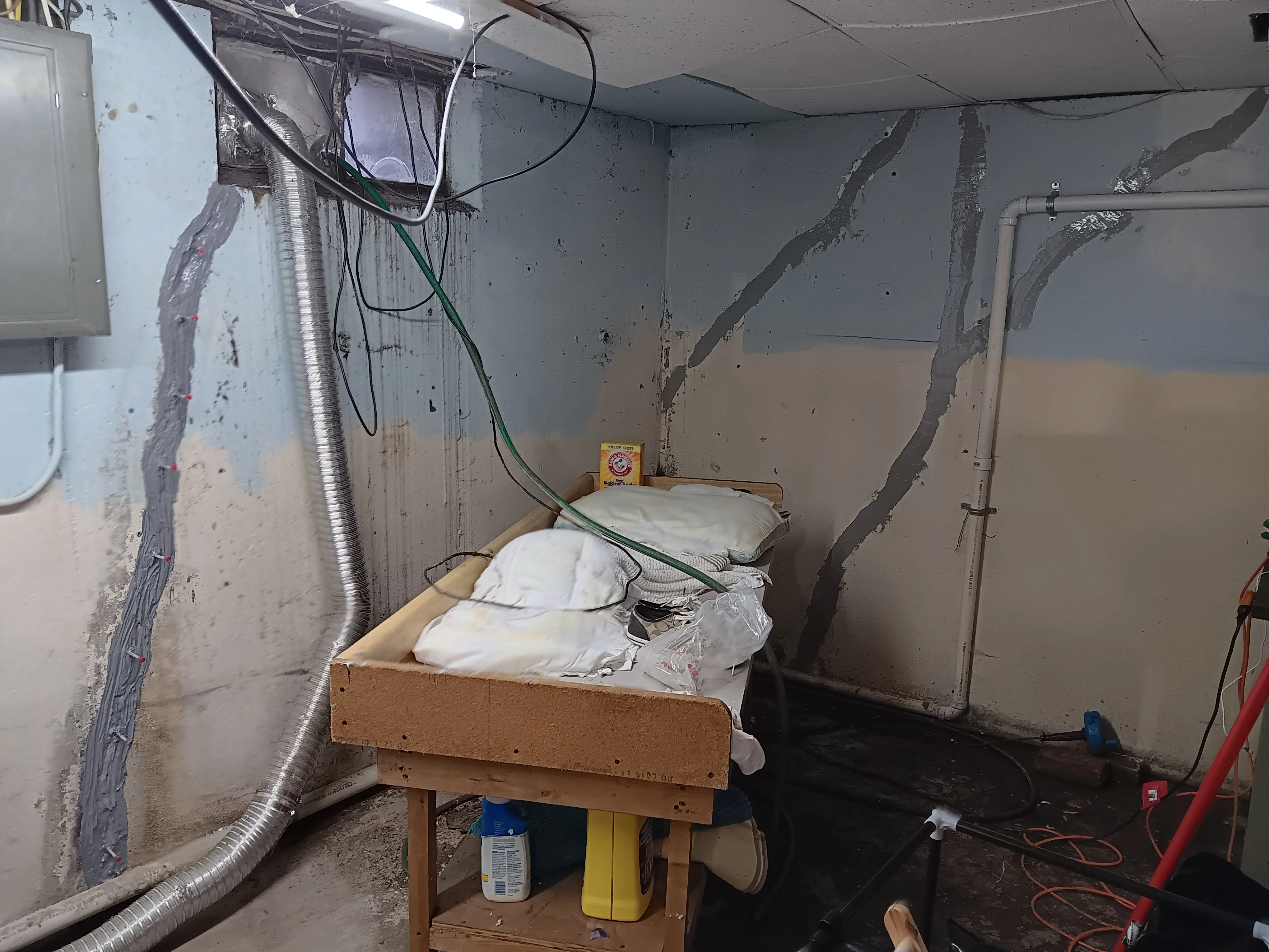 Basement foundation wall with vertical cracks sealed and waterproofing materials installed